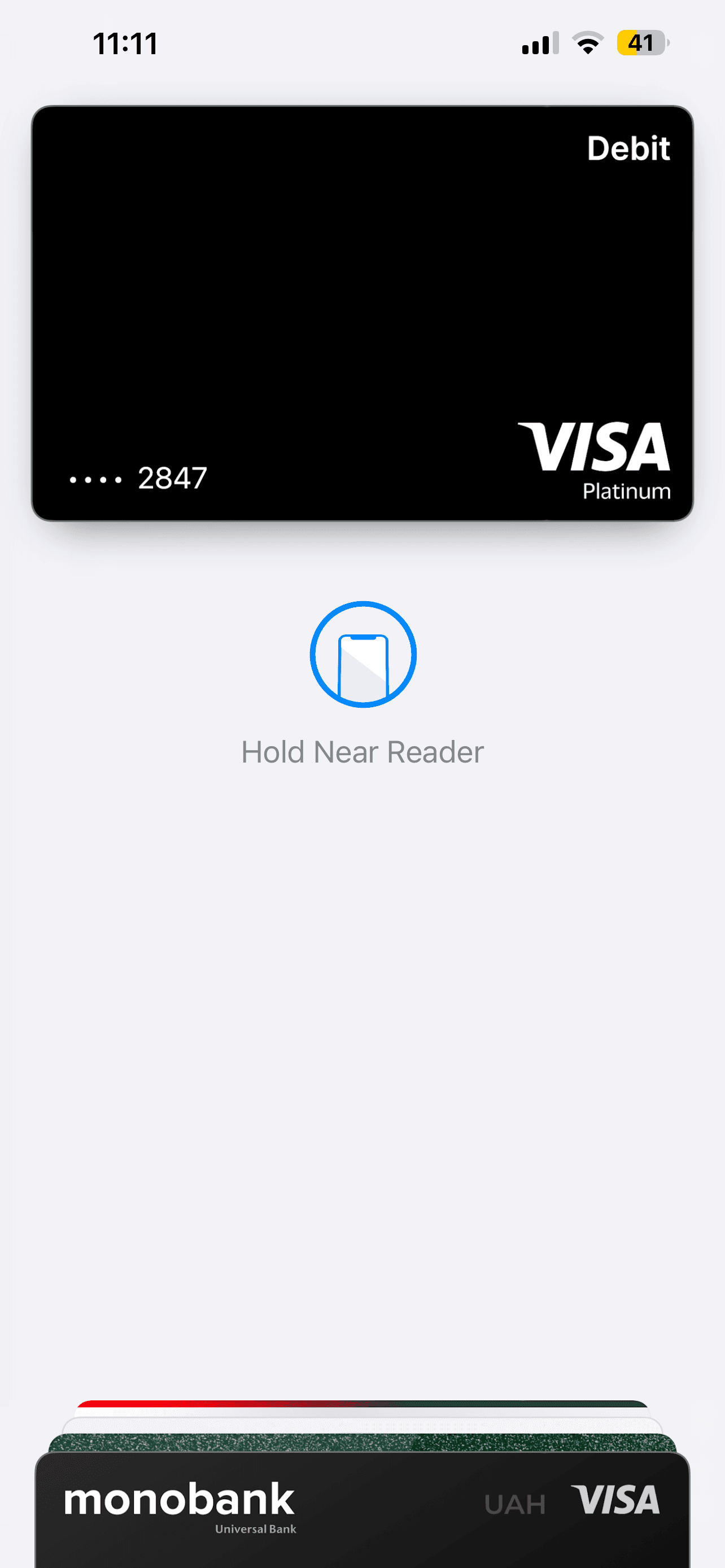 Holding an iPhone near a contactless reader to pay with Apple Pay